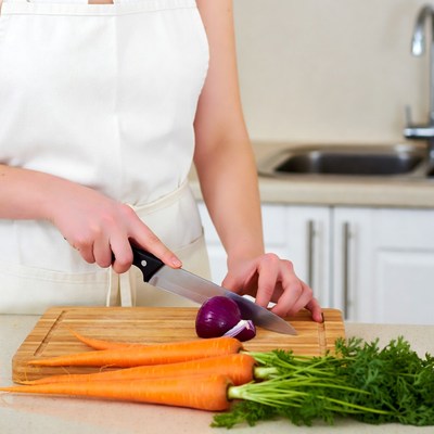 Woman chopping onion and carrots