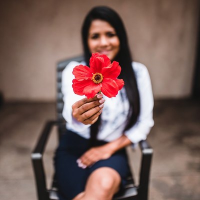 Latina woman holding red flower