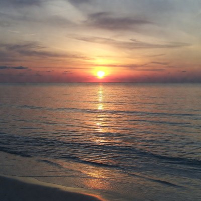 Sunset over calm ocean beach