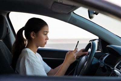 Asian girl texting while driving