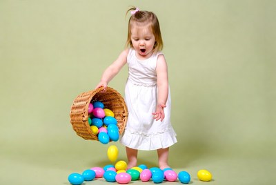 Toddler girl spilling colorful Easter eggs