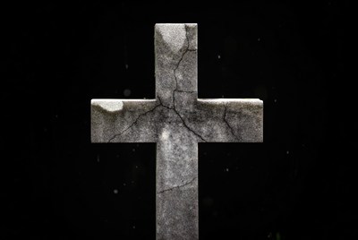 Cracked Stone Cross on Black Background