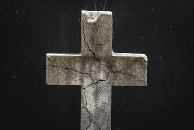 Cracked Stone Cross on Black Background