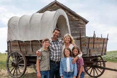 Family posing by covered wagon