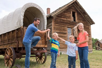 Family posing by covered wagon