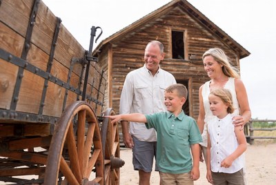 Family examining old wooden wagon