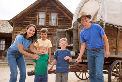 Family posing by covered wagon