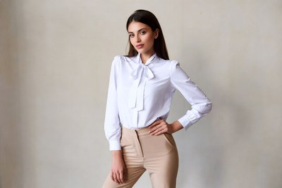 Woman in white bow blouse and beige pants