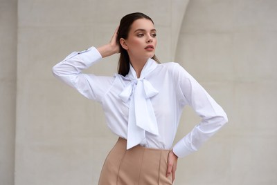 Woman in white bow blouse and beige skirt