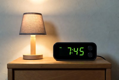 Digital Clock Showing 7:45 Next to Lamp