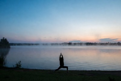 Silhouette woman doing yoga by lake