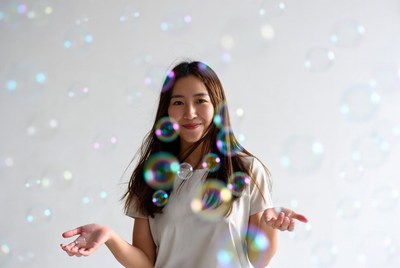 Asian woman surrounded by soap bubbles