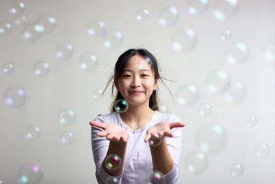 Asian girl holding soap bubbles