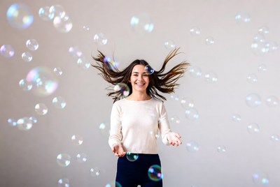 Woman blowing bubbles with flowing hair