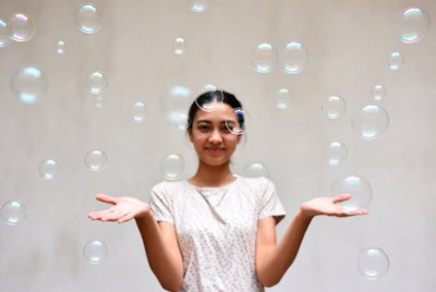 Asian woman with floating soap bubbles