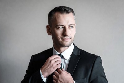 Man adjusting black tie suit