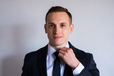 Man adjusting black tie in suit