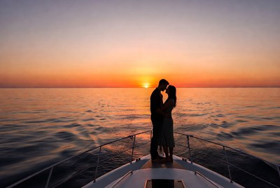Silhouette couple kissing on yacht at sunset