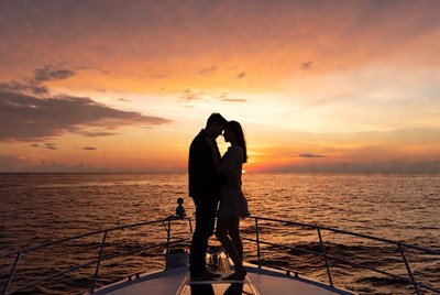 Silhouette couple kissing on yacht at sunset