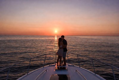 Couple kissing on yacht at sunset