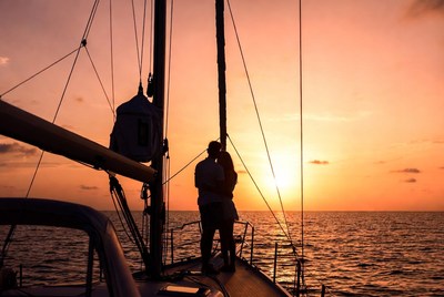 Silhouette couple embracing on yacht at sunset