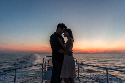 Couple embracing on boat at sunset