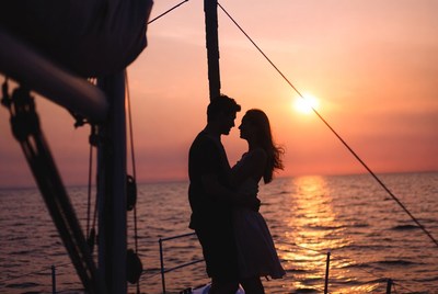 Silhouette couple embracing on yacht at sunset