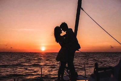Silhouette couple kissing on yacht at sunset
