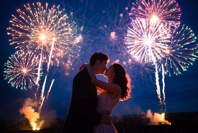 Couple kissing silhouetted against fireworks