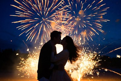 Silhouette couple kissing amid fireworks