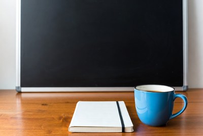 Notebook and Blue Coffee Mug by Blackboard