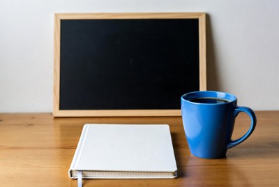 Blackboard with notebook and coffee mug