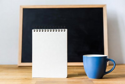 Notebook and Blue Mug by Chalkboard