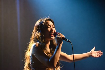 Asian woman singing on stage