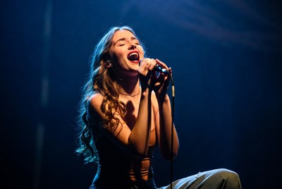 Woman singing passionately into microphone