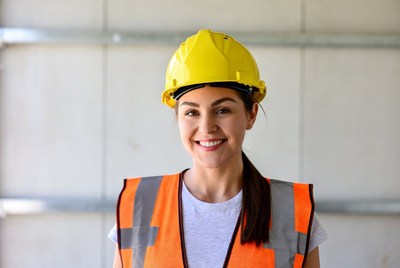Smiling woman in hard hat and vest