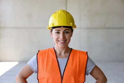 Smiling woman in hard hat and vest