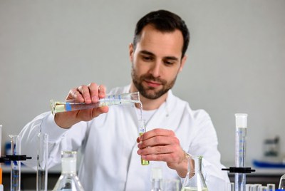 Man pouring liquid in lab