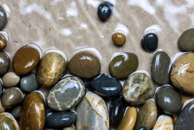 Wet Pebbles on Sandy Beach