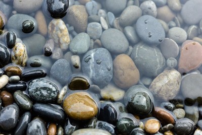 Wet colorful pebbles underwater