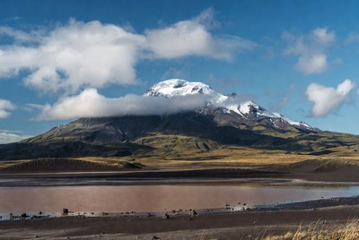 Snow-capped volcano over pink lake