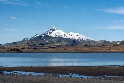 Snow-capped volcano reflecting in lake