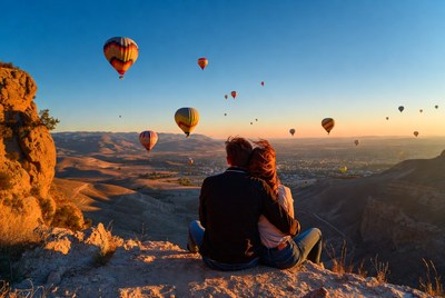 Couple watching hot air balloons at sunset