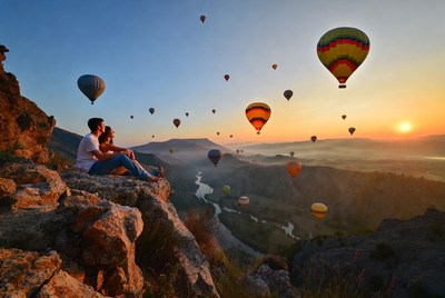 Couple watching hot air balloons at sunset