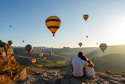 Couple embracing amid hot air balloons