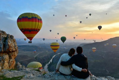 Couple embracing amid hot air balloons