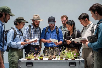 Group examining plants on table