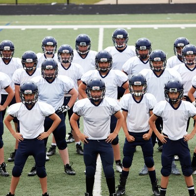 Youth football team posing on field