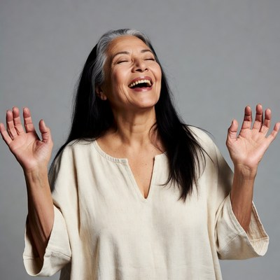 Asian woman laughing with arms raised
