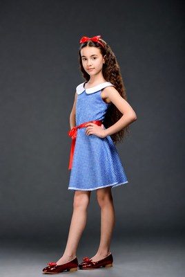 Girl in blue checkered dress with red bow